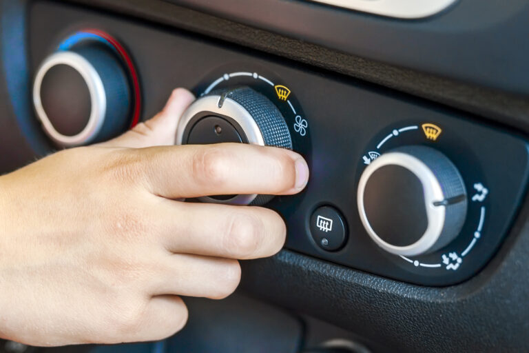 Closeup of a human hand rotating car temperature control, shallow depth of field shot