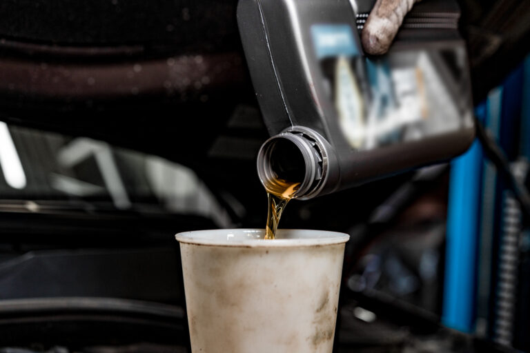 Pouring new oil to the car engine close up